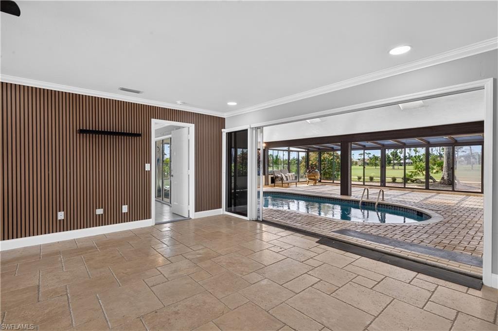 Indoor-outdoor living space featuring stone tile flooring and a slatted accent wall
