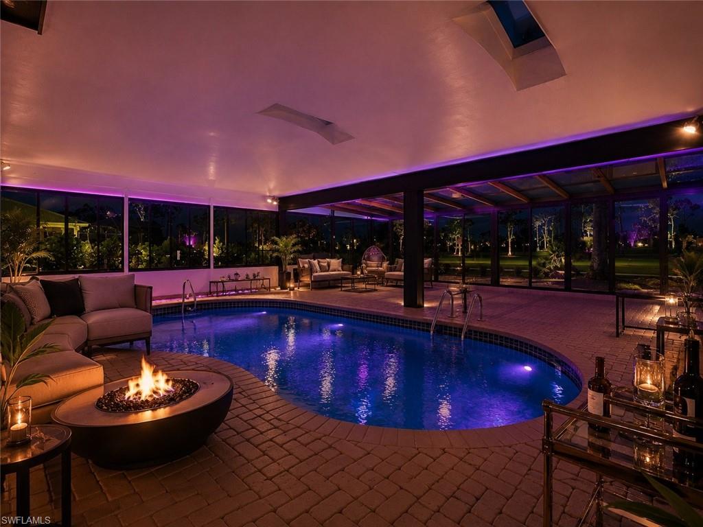 Indoor pool with a brick paver deck, a built-in fire pit, and skylights, Virtually Staged