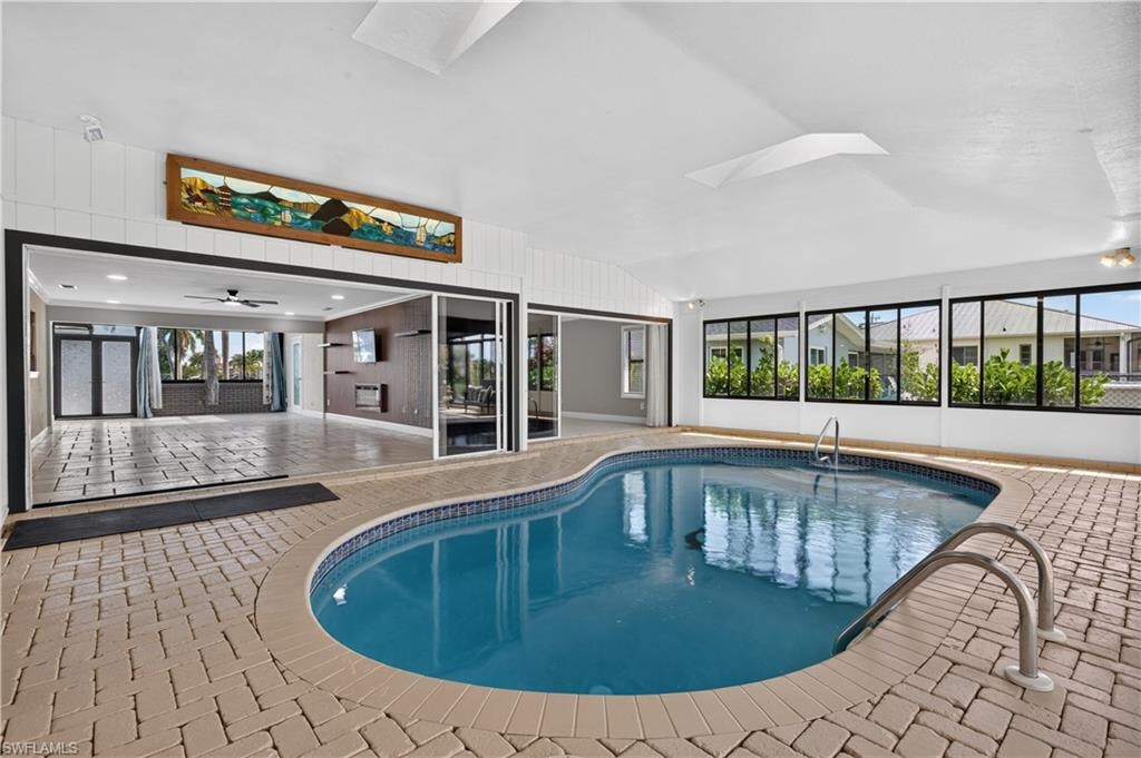 Indoor pool area featuring a freeform pool with integrated steps and a metal handrail