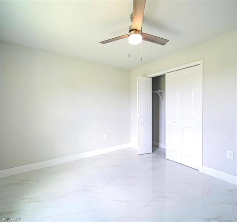 Room featuring light-toned walls and gleaming tile flooring