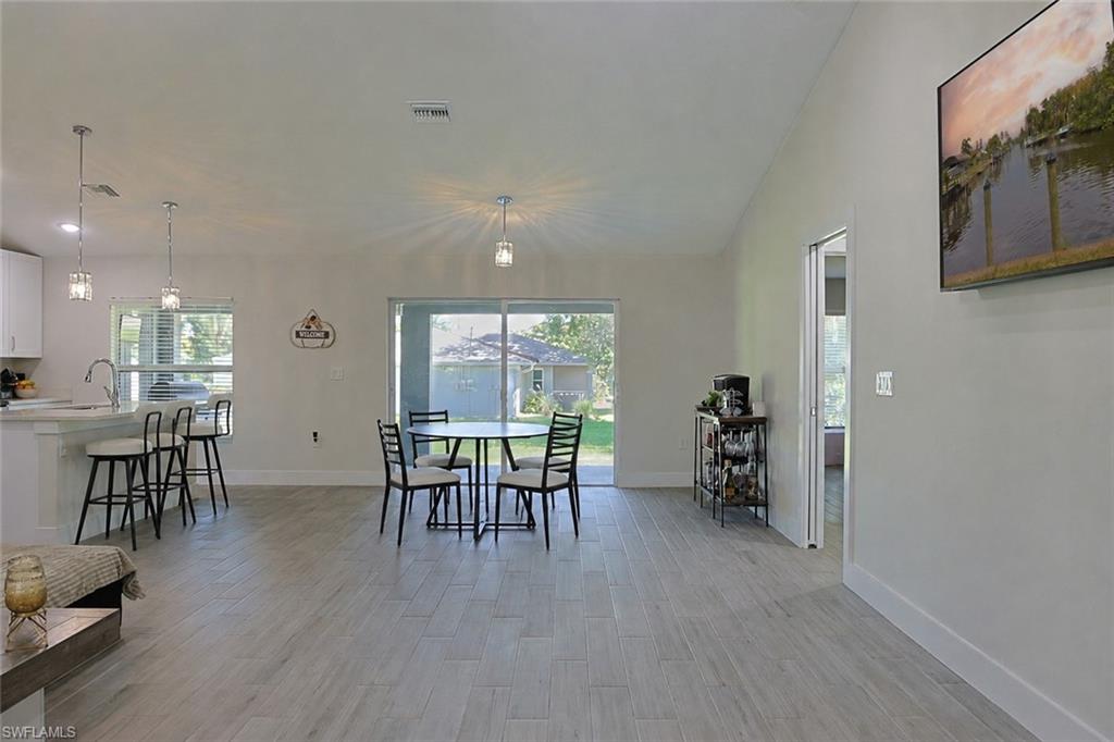 Open-concept living space featuring wood-finish flooring, recessed lighting, and a cathedral ceiling
