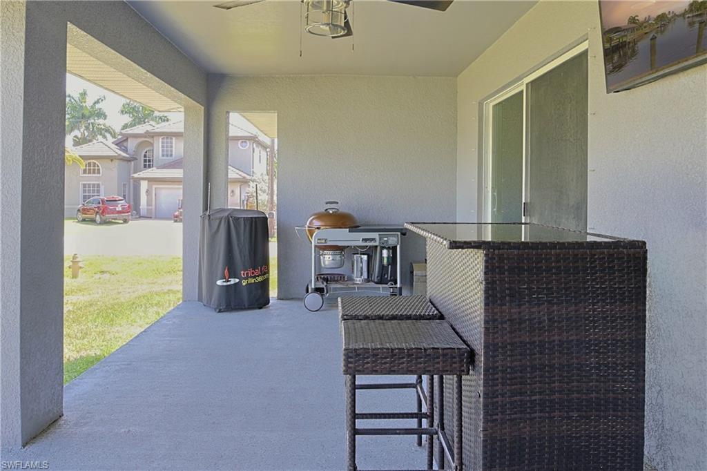 Covered patio featuring a ceiling fan, concrete flooring, and sliding glass door access