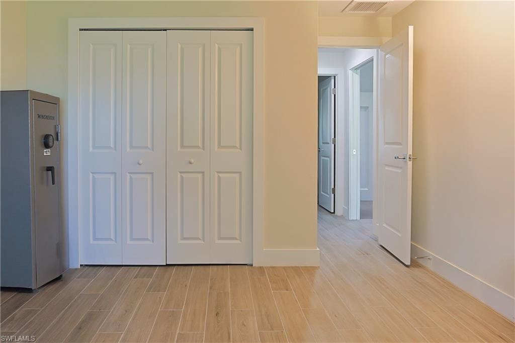 Expansive wood-finish tile flooring extends throughout, complemented by crisp white baseboards and trim
