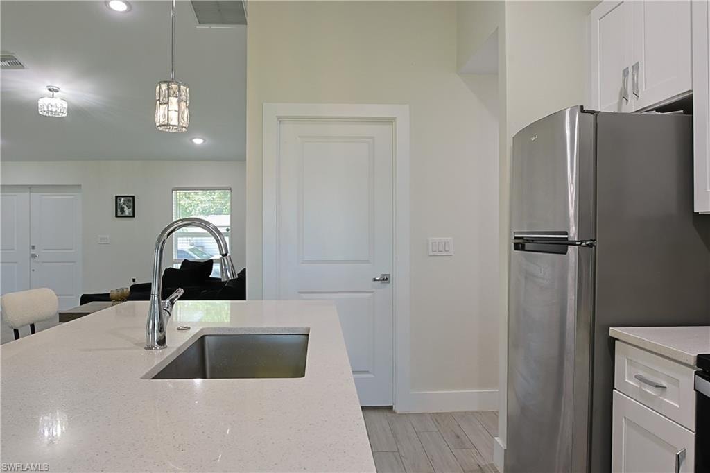 Kitchen island featuring a stainless steel sink with a gooseneck faucet
