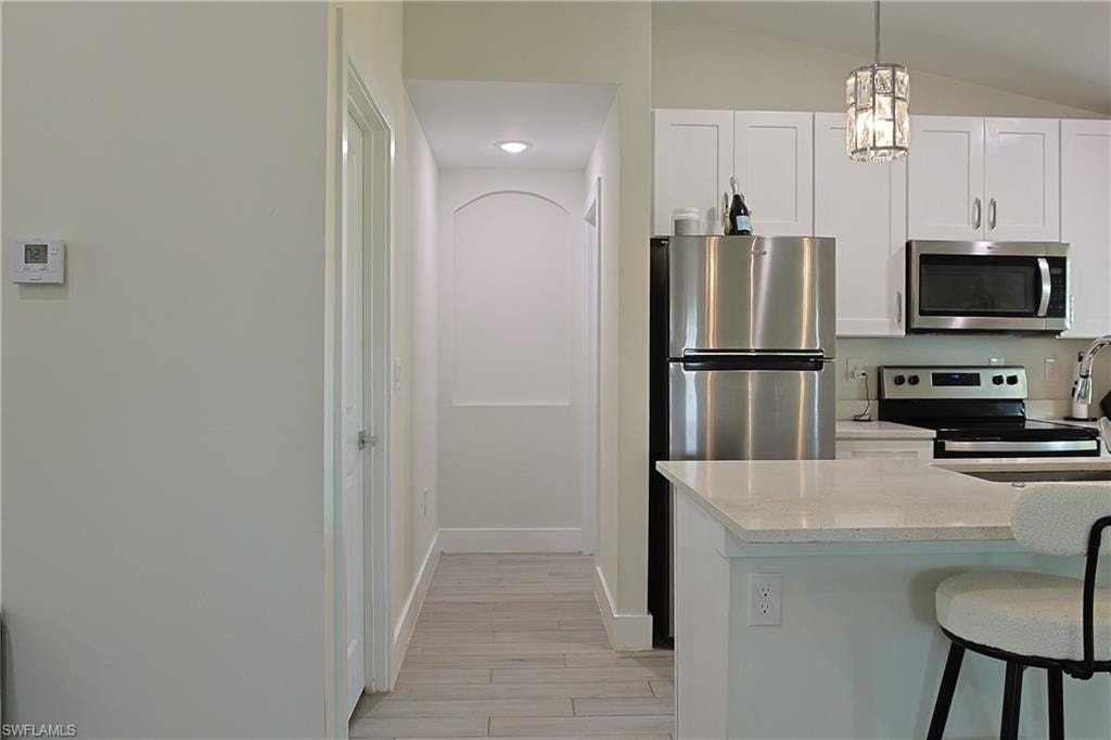 Kitchen featuring white shaker cabinetry, stainless steel appliances, and light-toned countertops