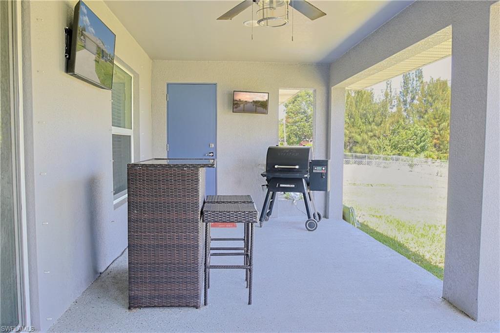 Covered patio with a light gray concrete floor and textured walls