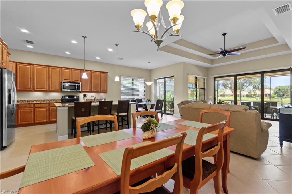 Open-concept living area with tile flooring and a tray ceiling