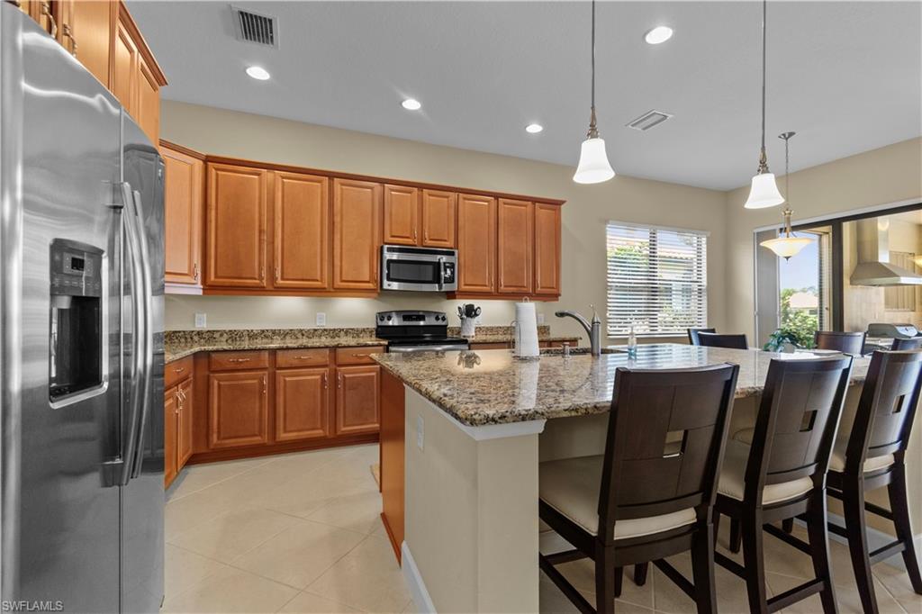 Well-appointed kitchen featuring wood cabinetry, stainless steel appliances, granite countertops, and recessed lighting