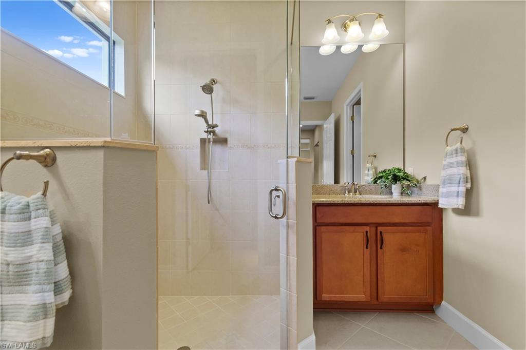 Walk-in shower with clear glass enclosure and overhead window