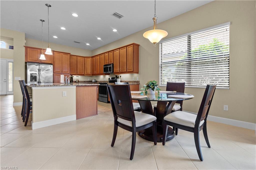 Kitchen featuring wood cabinetry, stainless steel appliances, and stone countertops