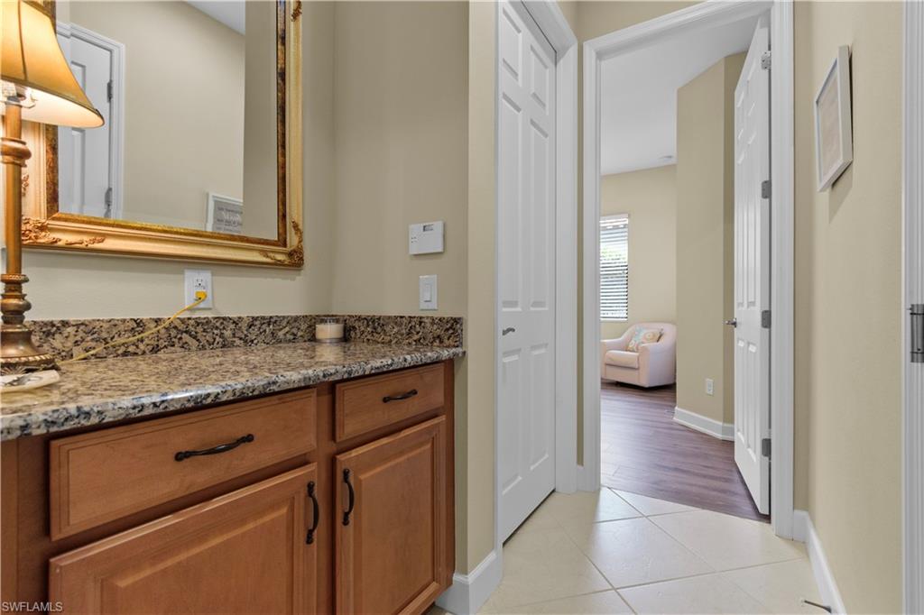 Hallway to guest bedroom with built-in cabinetry featuring a granite countertop
