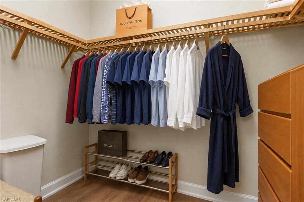 Primary bedroom features two large walk-in closets with wood-finish shelving