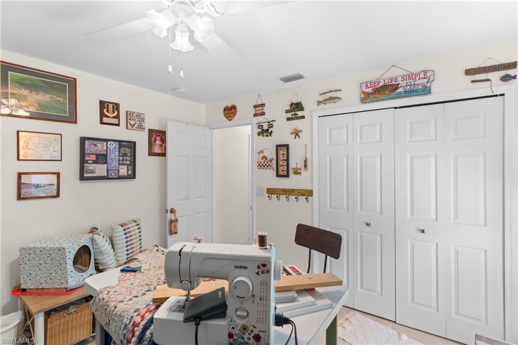 Room featuring a ceiling fan with light fixture, neutral wall color, and white bi-fold closet doors