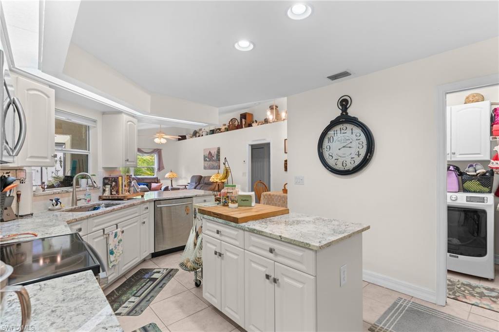 Kitchen featuring white cabinetry, light-toned countertops, and stainless steel appliances