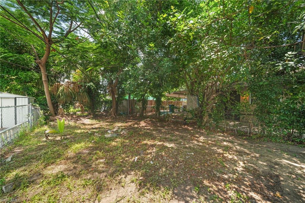 Expansive backyard featuring mature trees and established perimeter fencing