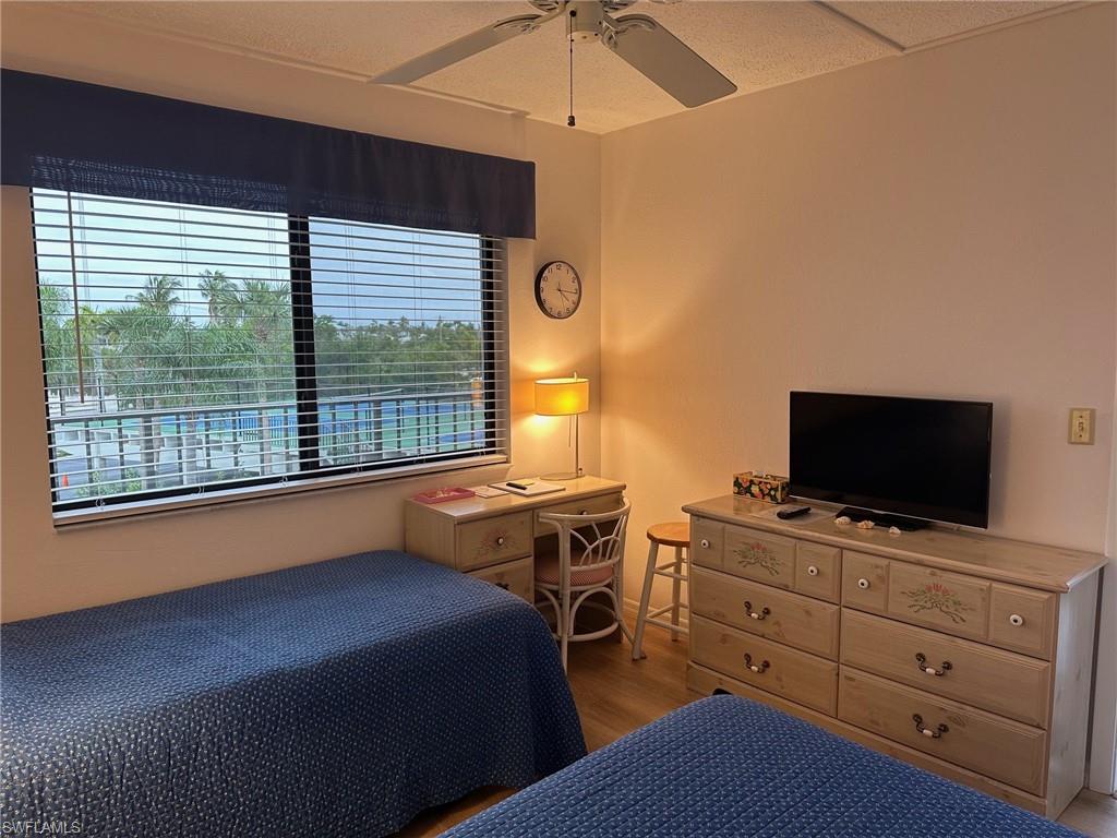 Room featuring light wood-finish flooring, a window with horizontal blinds, and a ceiling fan