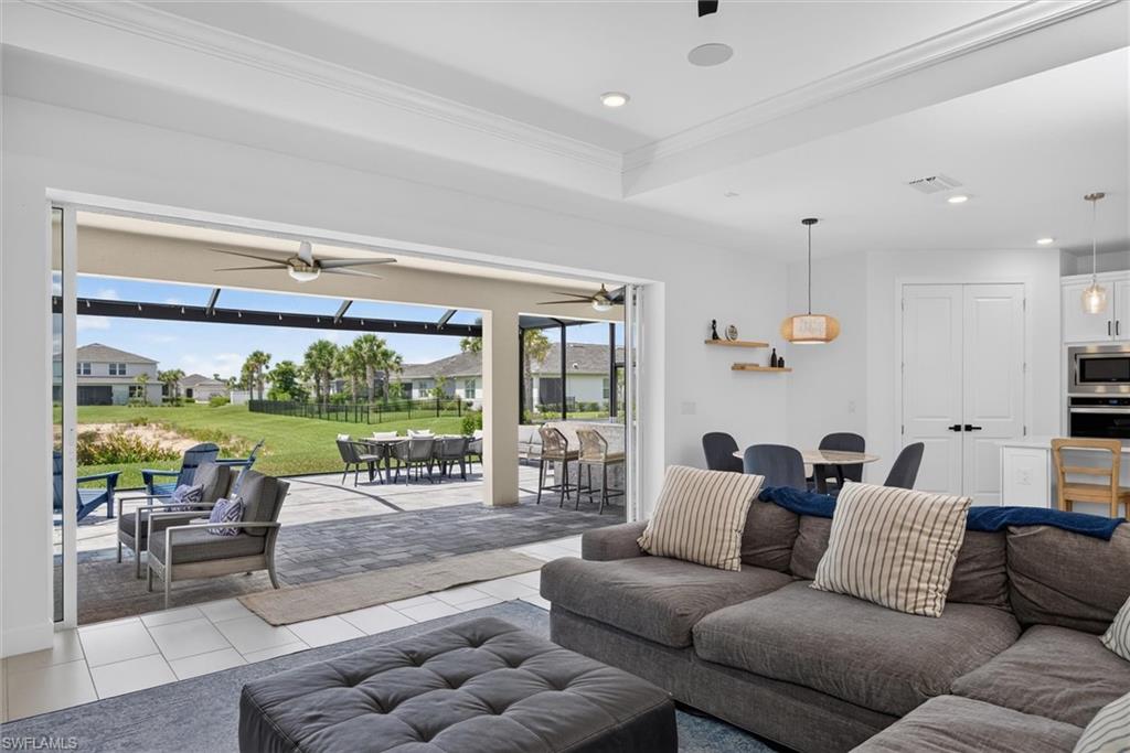 The spacious living space features dramatic pocket sliders that blur the lines between indoors and out, filling the home with natural light and showcasing the inviting outdoor living space