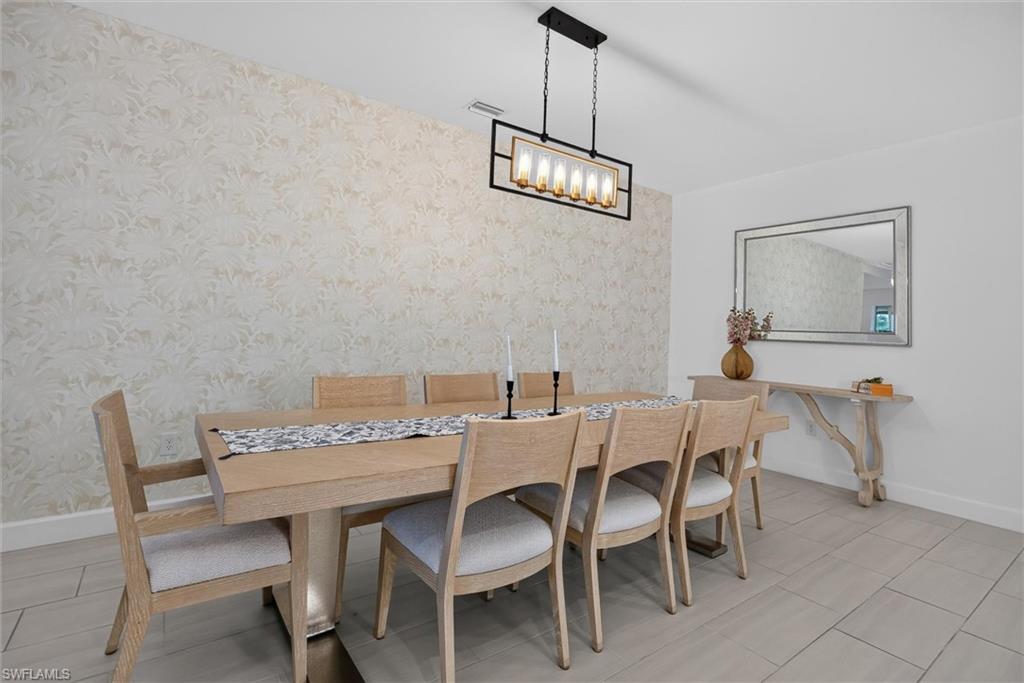 Dining Room for plenty of room for those special meals and or gatherings with friends/family, featuring tasteful wallpaper