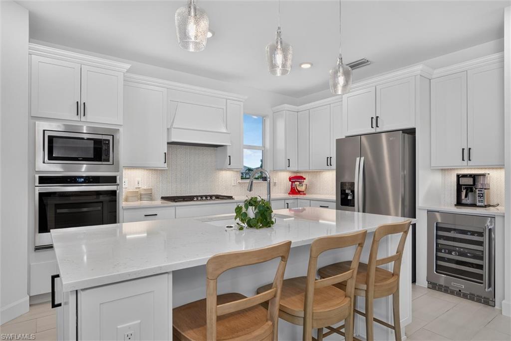 Kitchen with ample cabinet, don't miss the cabinets on the ends of the island for extra storage and notice the window to bring in extra lighting