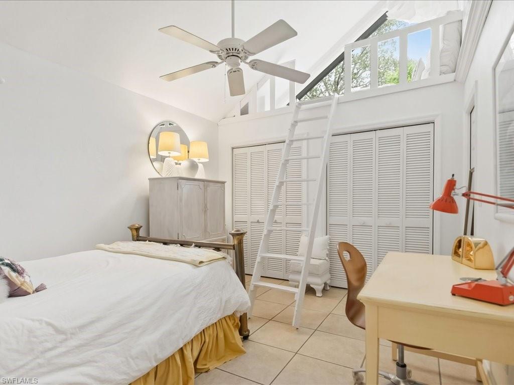 Vaulted ceiling room featuring a loft, ceiling fan, and louvered bifold closet doors
