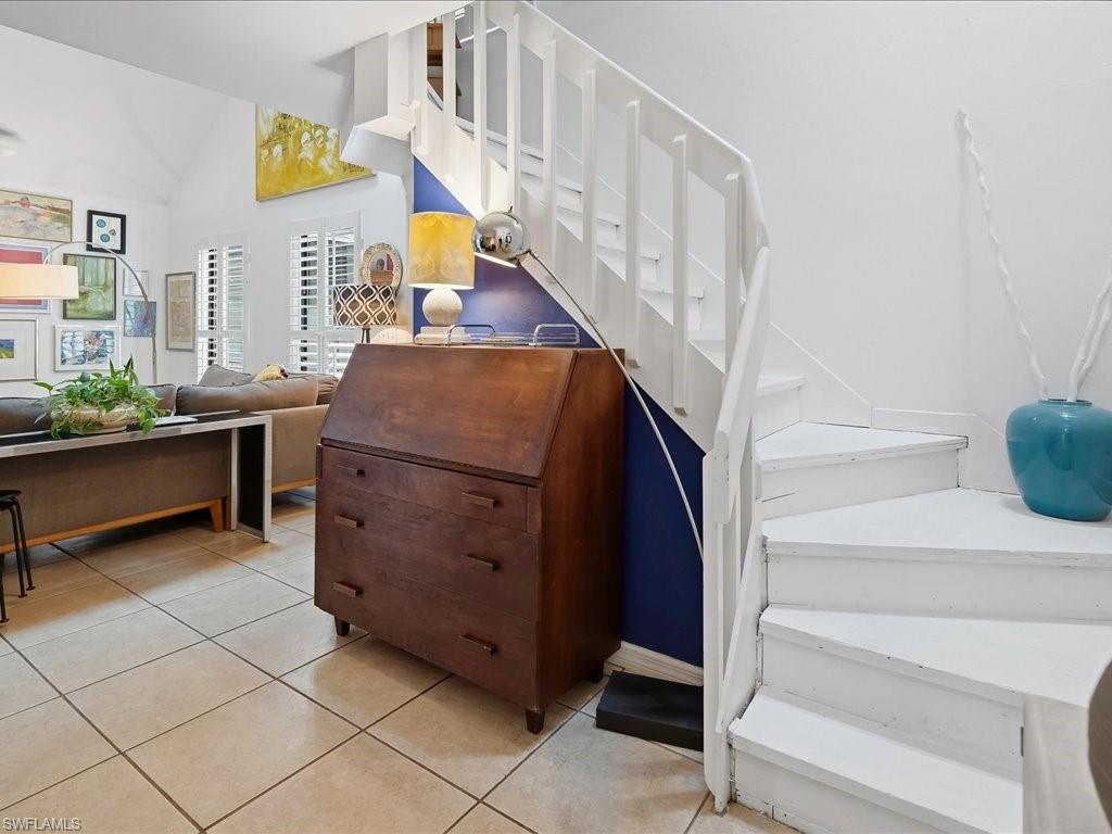 White painted wooden staircase with open risers and a partial blue accent wall