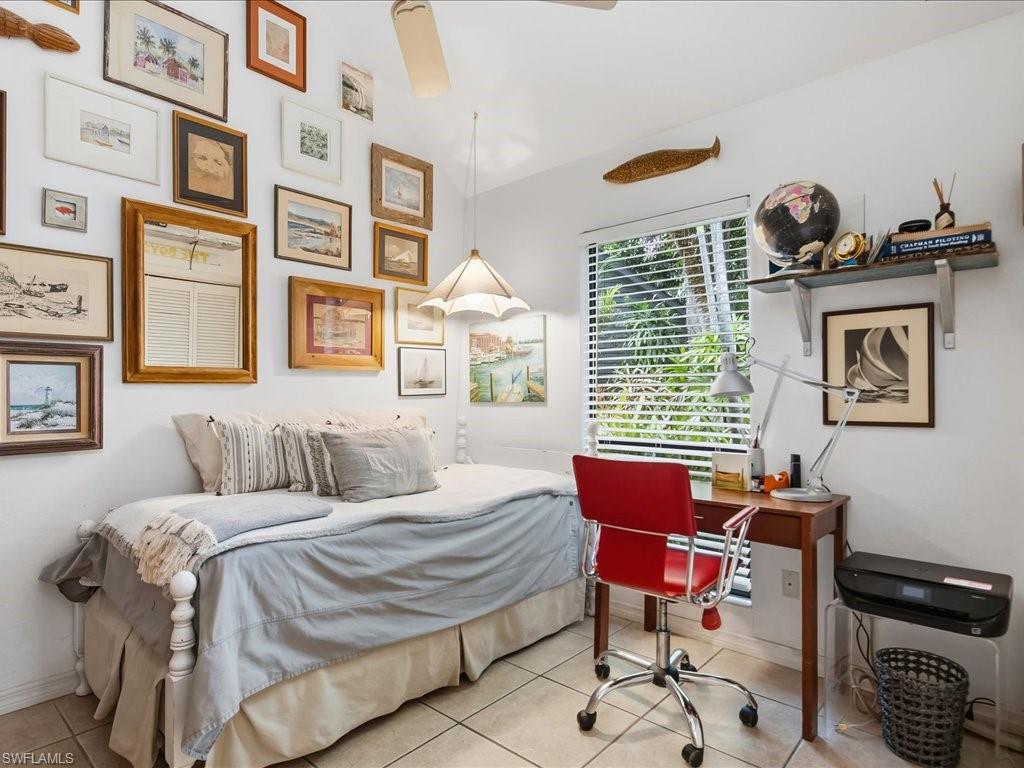 Bright interior space featuring a window with white blinds, ceramic tile flooring, a built-in ceiling fan