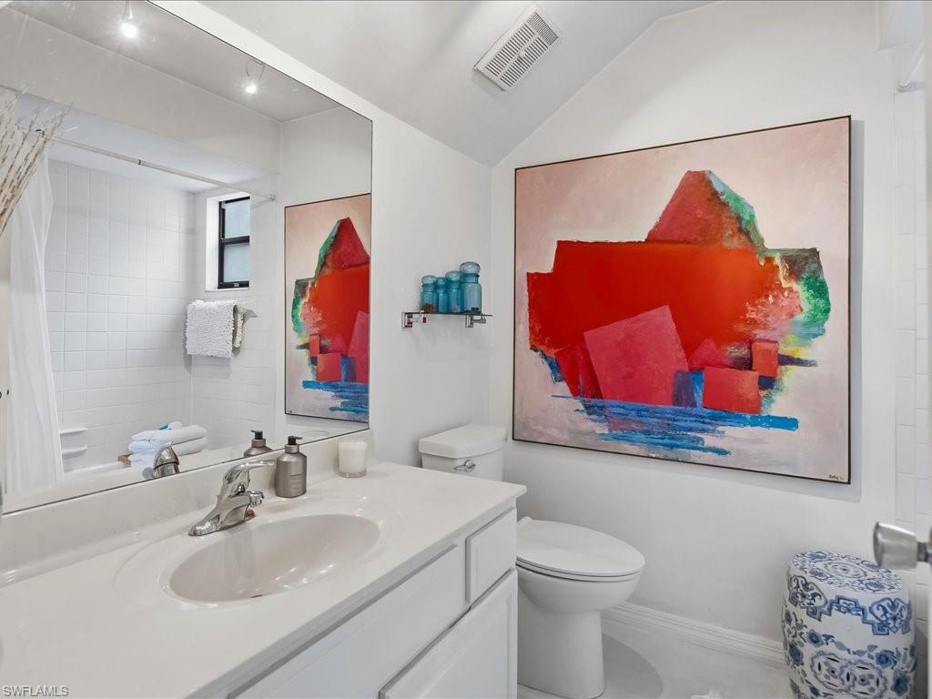 Bathroom featuring a single vanity with an integrated sink, polished chrome faucet, and white countertop