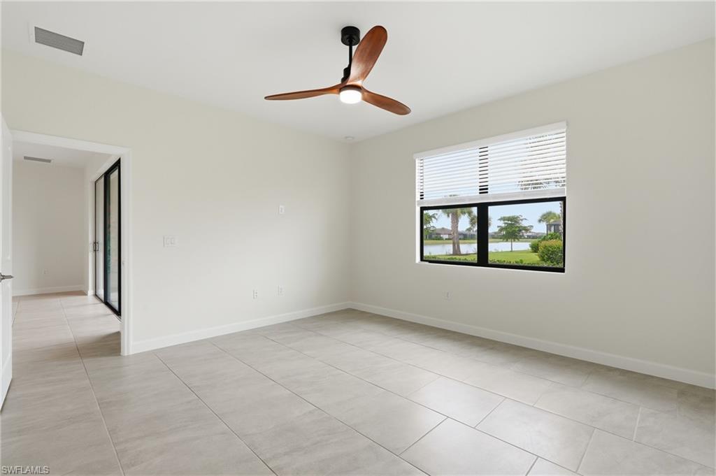 Bright interior space featuring light-toned tile flooring and a ceiling fan with integrated lighting