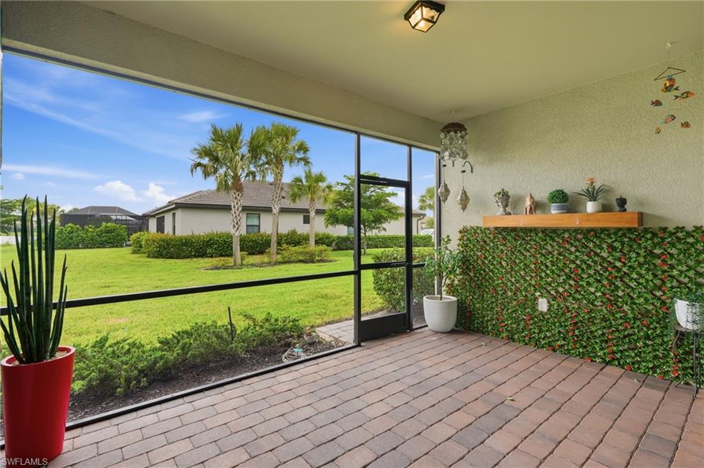 Screened patio featuring brick-finish flooring and a decorative wall covering