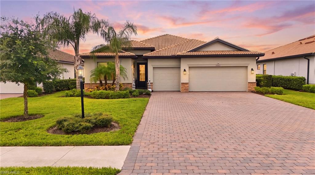 Single-story residence featuring a tile roof and a paver driveway
