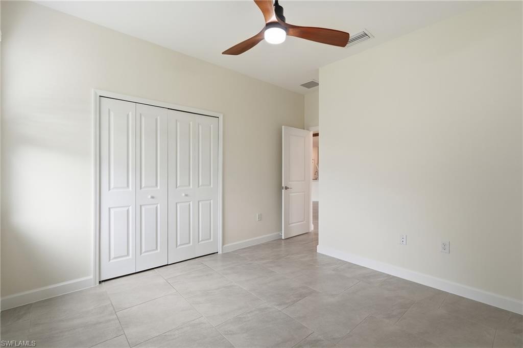 Neutral-toned interior room featuring light gray tile flooring and white baseboards