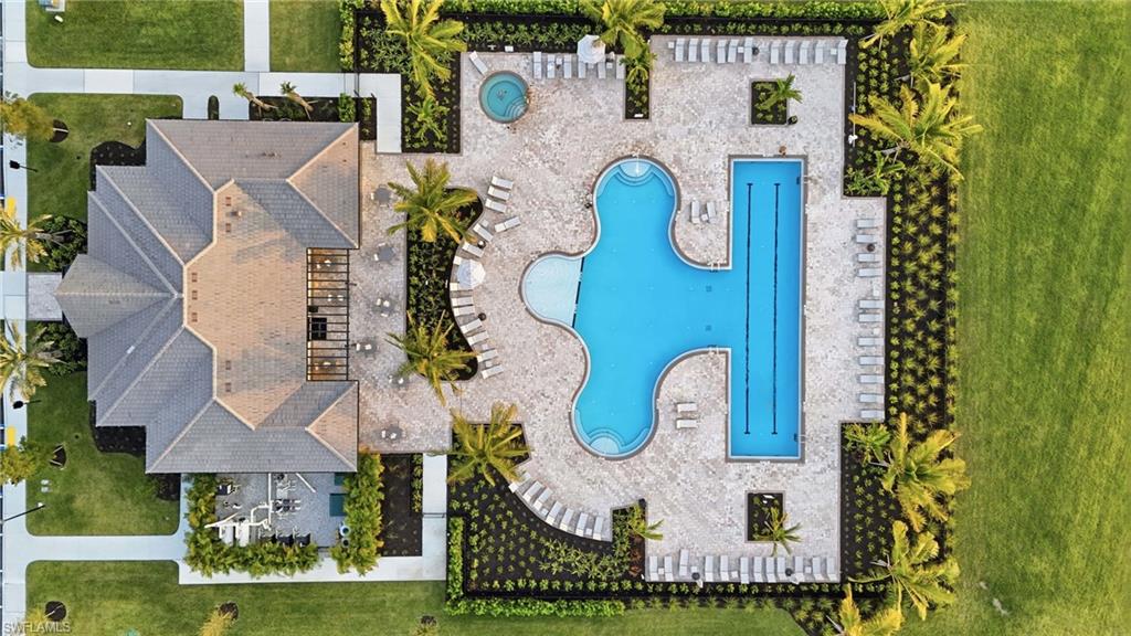 Community amenities featuring a clubhouse with a multi-gabled roof, extensive pool deck, a large freeform pool, a lap pool, and a circular spa