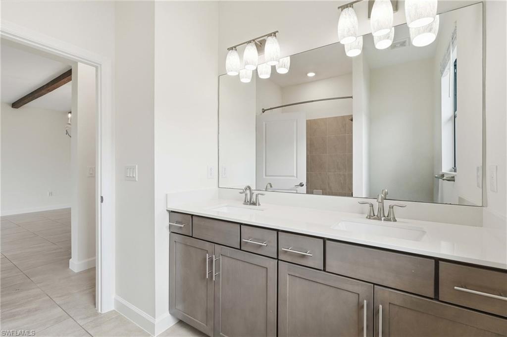 Dual vanity featuring a white countertop, brushed nickel faucets, and under-sink cabinetry