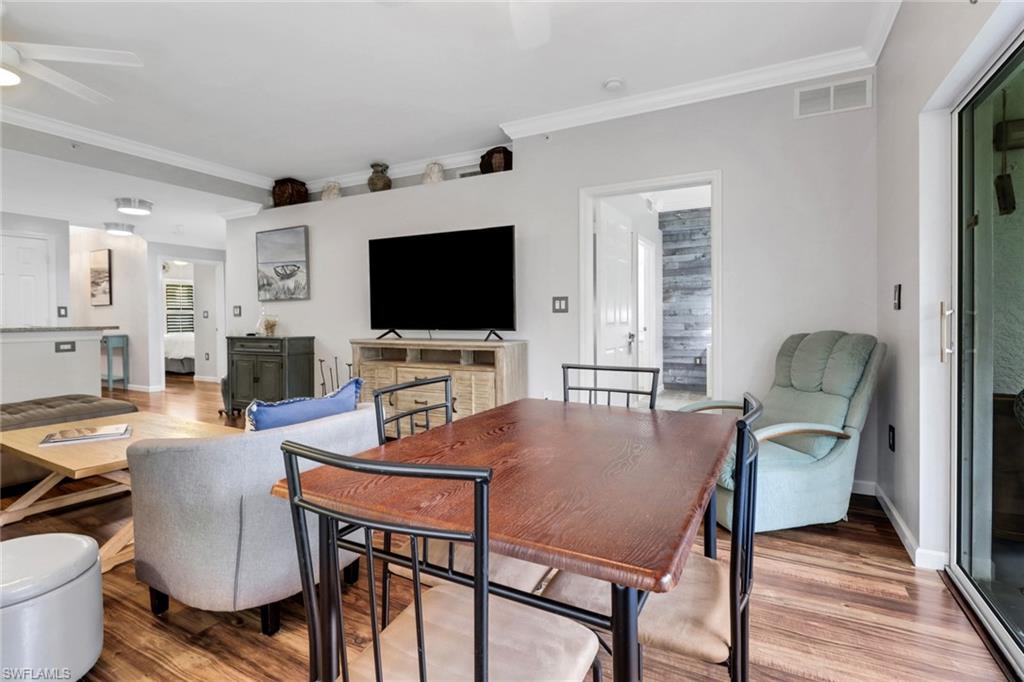 Dining room featuring ceiling fan, wood finished floors, ornamental molding, and baseboards