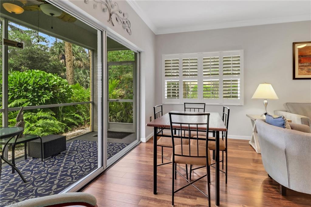 Dining room with wood finished floors, ornamental molding, and baseboards