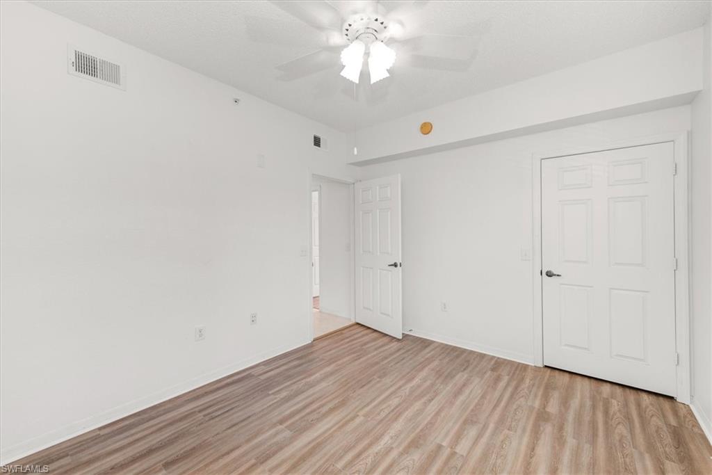 3rd bedroom featuring light wood-finish flooring, white walls, and a ceiling fan with integrated lighting