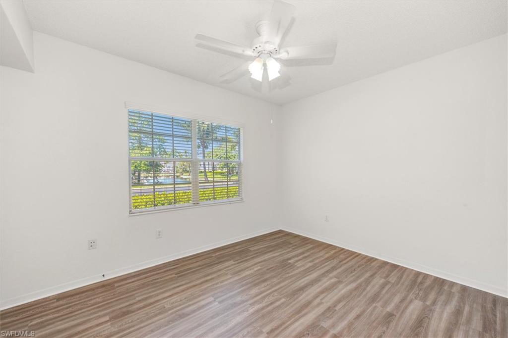 3rd bedroom featuring wood-finish flooring, a white ceiling fan with integrated lighting, and a window with horizontal blinds