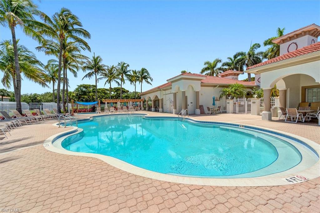 Resort-style swimming pool featuring a curved design and brick paver decking