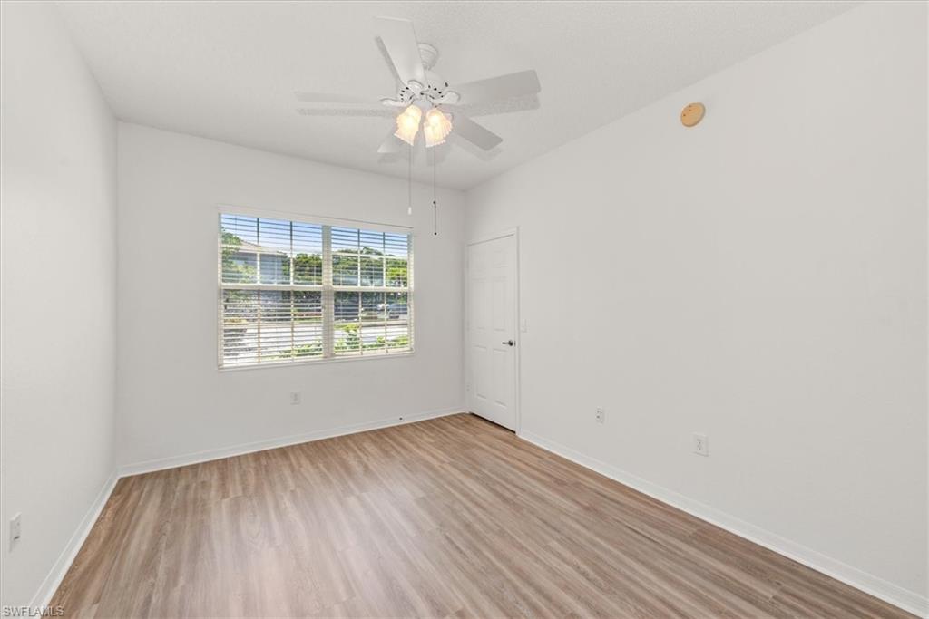2nd bedroom featuring wood-finish flooring, a ceiling fan with integrated lighting, and a window with horizontal blinds