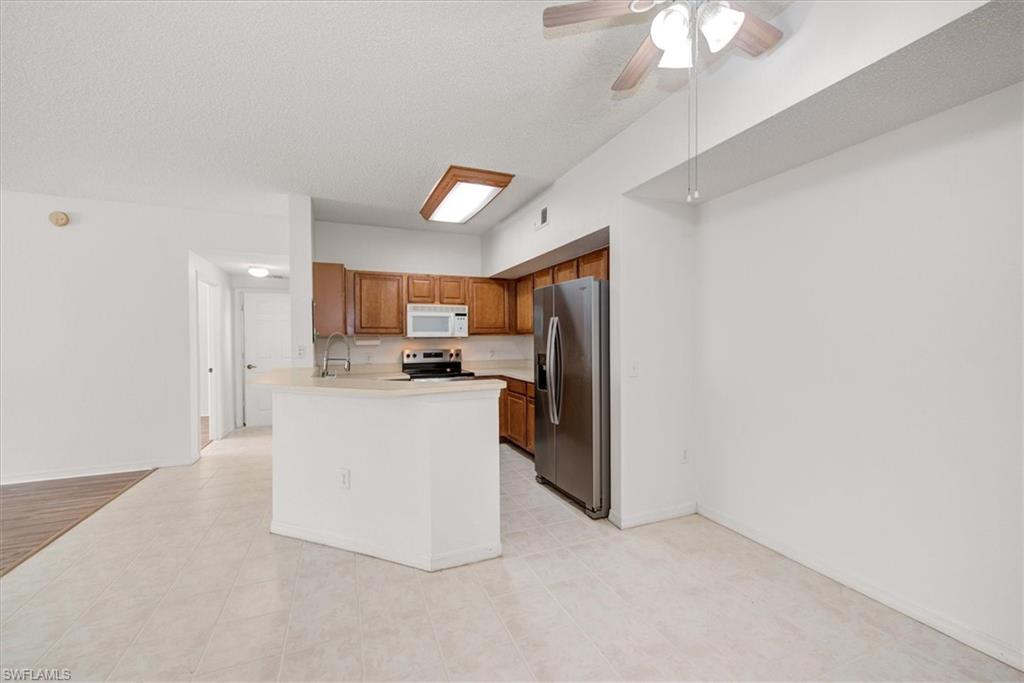 Kitchen with wood cabinetry, stainless steel appliances, and a breakfast bar