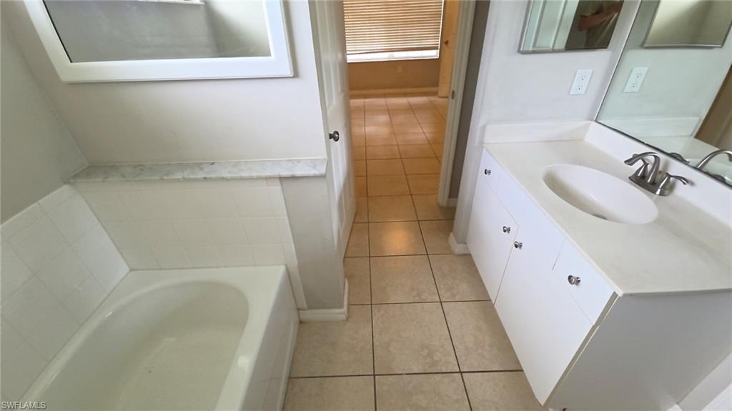 Bathroom featuring a white vanity with integrated sink, brushed nickel faucet, and a large wall mirror