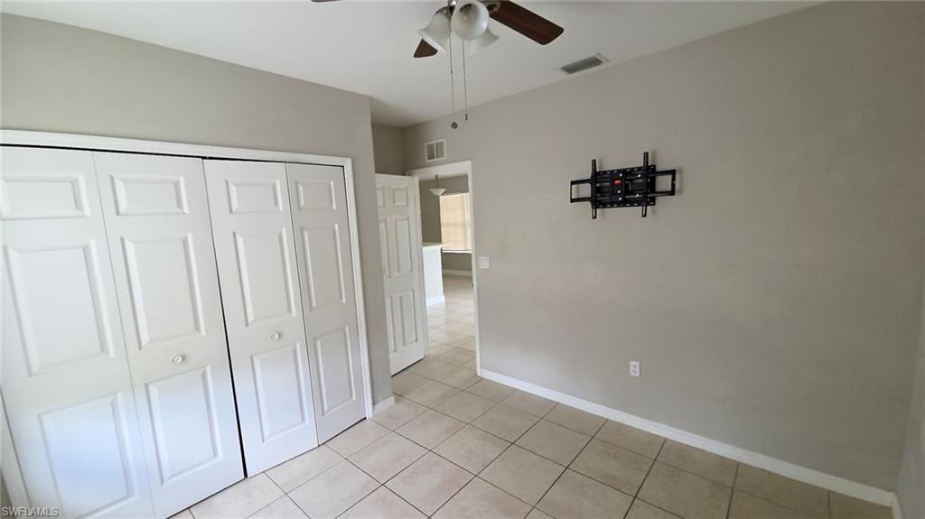 Neutral toned interior room featuring tile flooring and a ceiling fan