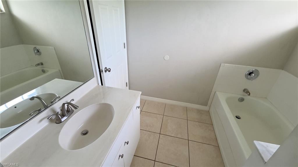 Bathroom featuring a single vanity with an oval sink, chrome faucet, and a large wall-mounted mirror