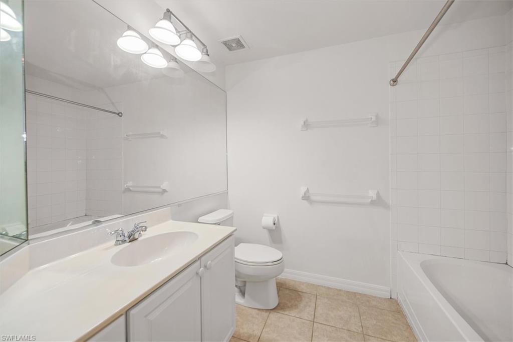 Bathroom featuring a white vanity with integrated sink, chrome faucet, and ample wall-mounted mirror