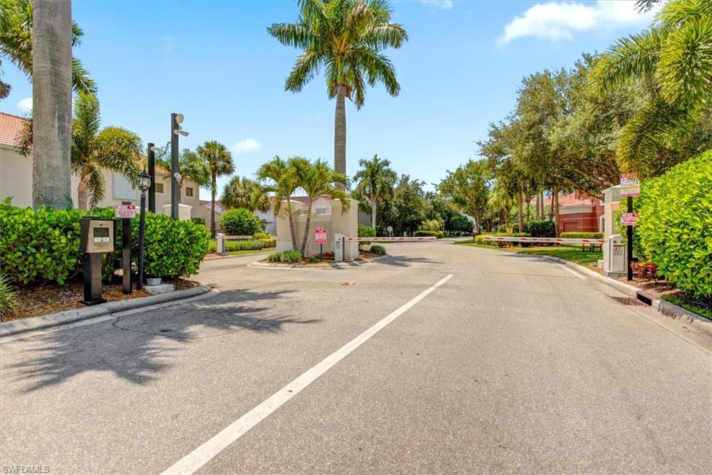 Gated entry featuring an intercom system, security cameras, and automated barrier arms