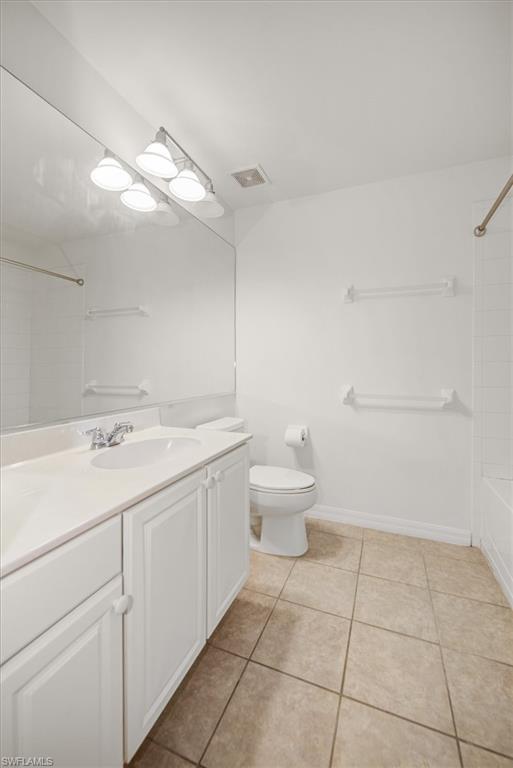 Bathroom featuring a single vanity with white cabinetry and a light-toned countertop, a large wall-mounted mirror, and a three-light vanity fixture