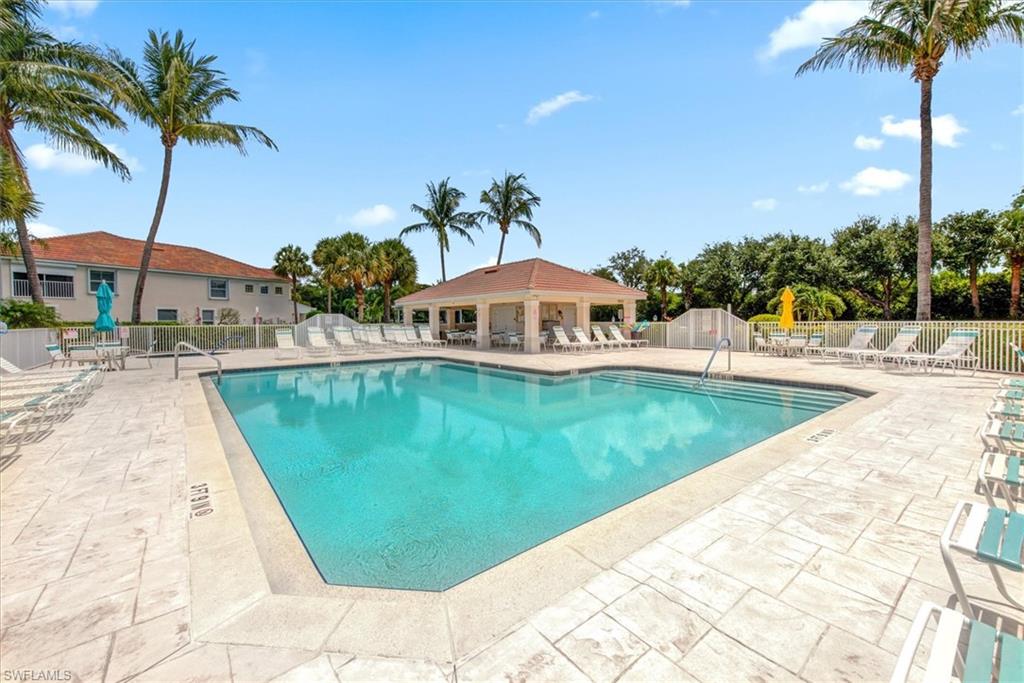 Resort-style pool area featuring a large swimming pool, surrounding stamped concrete decking, and a poolside gazebo with a hip roof