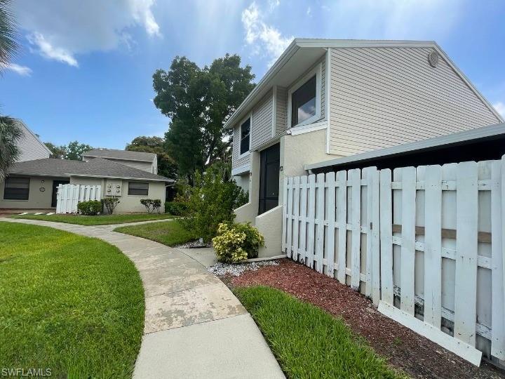 Two-story exterior with light-colored siding and a white privacy fence