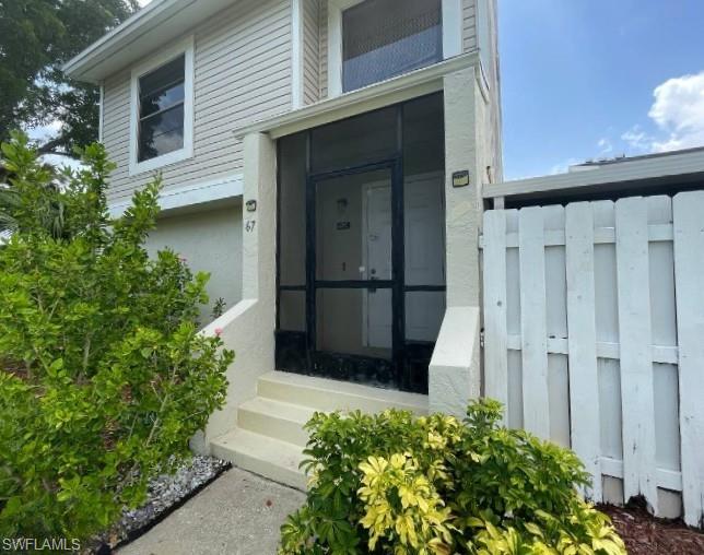 Screened entry porch with a white door and an exterior number display