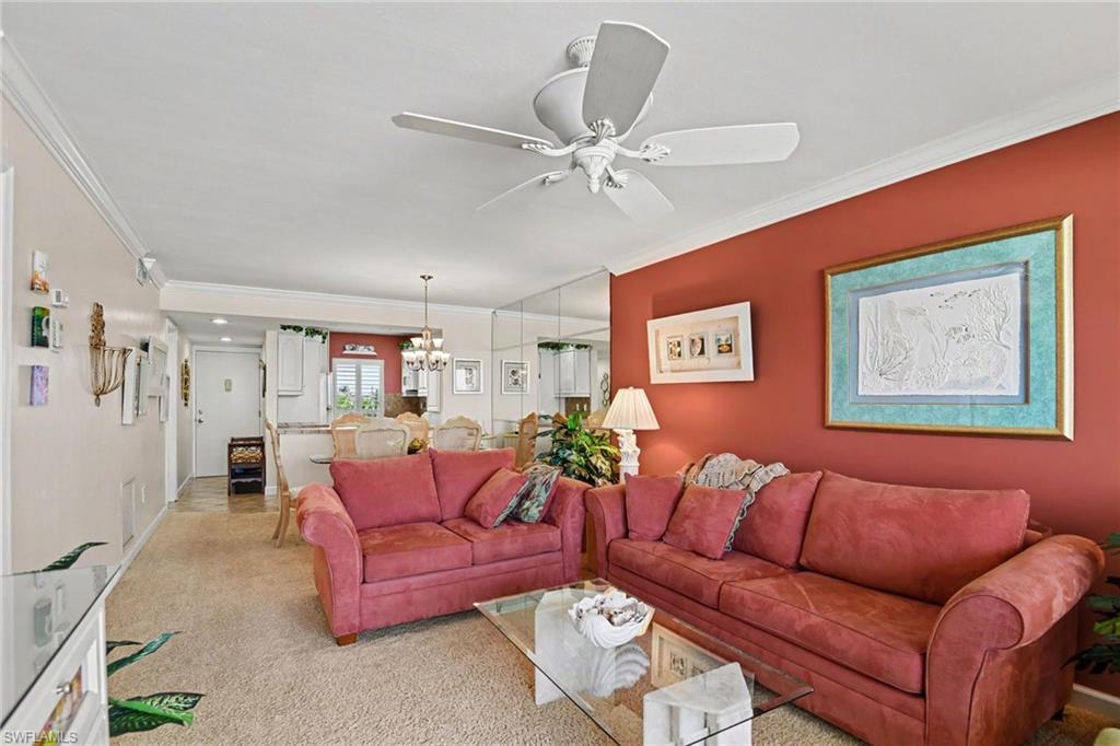 VIEW INTO LIVING AREA.  UPSCALE FURNISHINGS MAKE THE UNIT MOVE-IN READY. PRIMARY SUITE IS TO LEFT.  UNIT ENTRANCE, KITCHEN AND ENTRANCE TO GUEST BEDROOM SHOWN AT REAR.